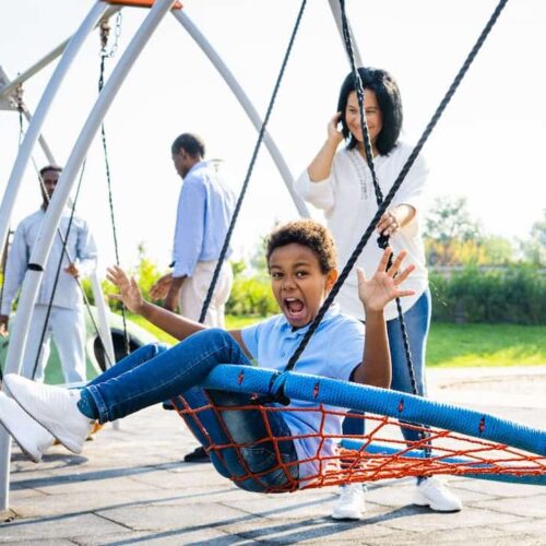 Enfant jouant en toute sécurité sur une aire de jeux équipée de dalles absorbantes