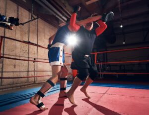 "Deux athlètes s'entraînant au kickboxing sur un tapis puzzle tatami dans un ring de boxe