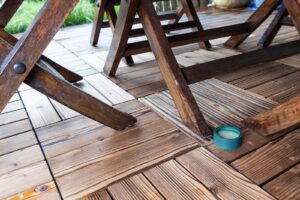 Terrasse en dalles clipsables en bois composite avec une table en bois, offrant un espace extérieur moderne et résistant.