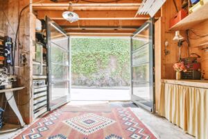 Garage bien rangé avec portes ouvertes, établi en bois et espace de rangement optimisé
