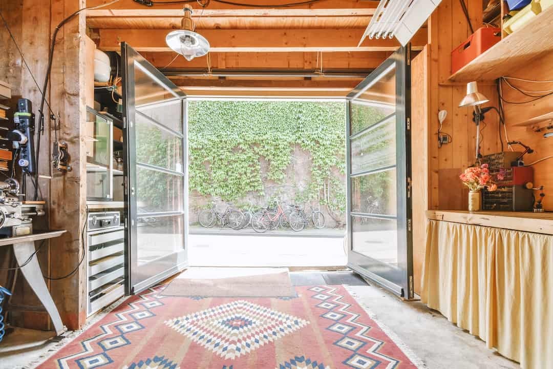 Garage bien rangé avec portes ouvertes, établi en bois et espace de rangement optimisé