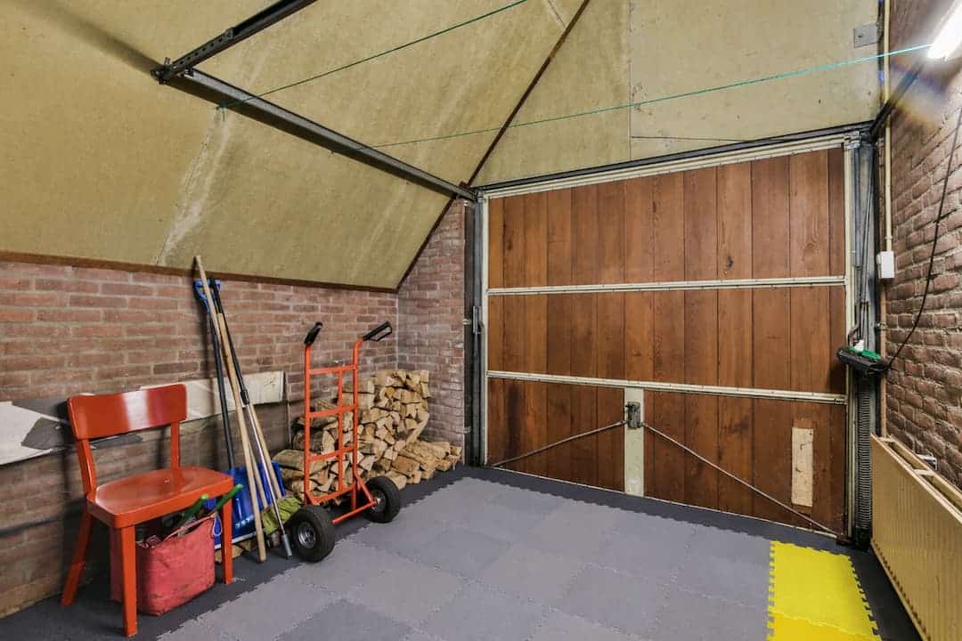 Intérieur de garage avec sol en dalles PVC modulaires grises, mettant en évidence la résistance dalle PVC garage aux usages quotidiens et au stockage d'outils.