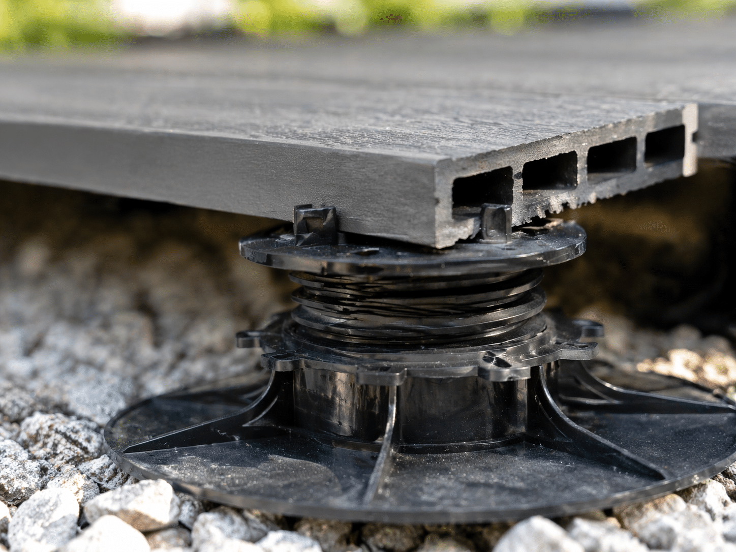 Gros plan sur un plot r&eacute;glable avec dalle composite correctement pos&eacute;e